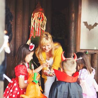 Woman handing out candy to trick-or-treaters