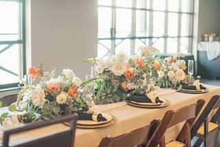 A beautifully arranged dining table features elegant floral centerpieces and fine tableware, creating a warm and inviting atmosphere.